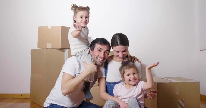 Portrait of a beautiful happy and smiling family holding the house shaped meter just arrived in the new house to start a new path together. Concept of: love, family, home.
