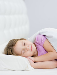 Obraz na płótnie Canvas little girl sleeping on the bed. Space for text