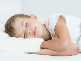 Obraz na płótnie Canvas close up little boy sleeping on the bed
