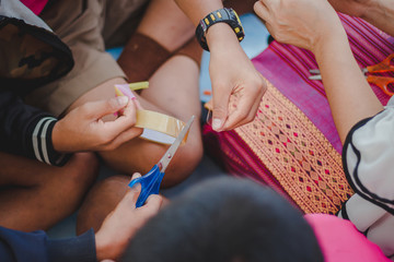 The Students are making straw flowers in classroom.