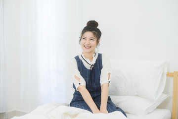 Beautiful Young Asian Woman Sitting On Bed and smile