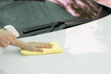 Close up woman hand cleaning car by micro fiber cloth. 