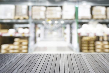 Fototapeta premium Empty top of wooden table and blurred warehouse background for display your products
