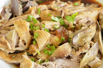 boiled duck in brown soup slice and topping chop spring onion on plate
