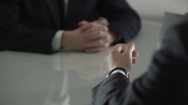 Man handing over white envelope with money, bribe to official, corruption