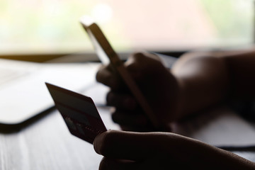 Online payment,Man’s hands holding the credit card and using smart phone for online shopping.