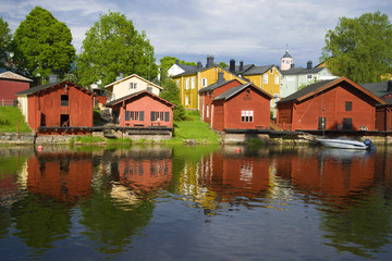 Fototapeta na wymiar Red old barns on the river bank on a sunny summer day. Old Porvoo, Finland