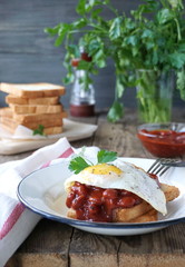 Toast with fried egg and beans on a plate