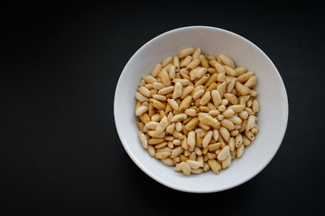 Puffed rice in white cup on dark background.