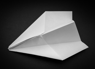 Paper plane on dark background. Selective focus.