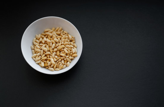 Puffed rice in white cup on dark background.