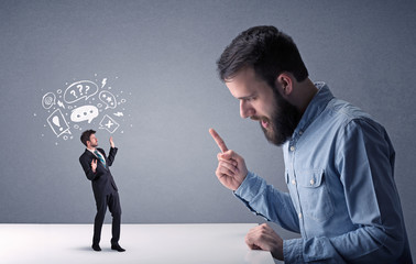 Young businessman fighting with miniature businessman