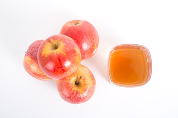 Top view of apple cider vinegar and apples on white background