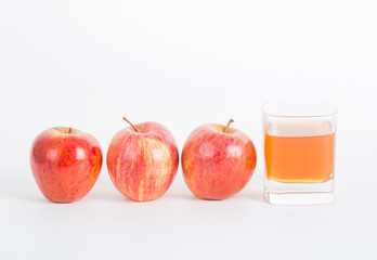 Three apples and one glass cup of apple vinegar