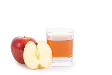 Apple cider vinegar in a glass cup and fresh apples on white background.