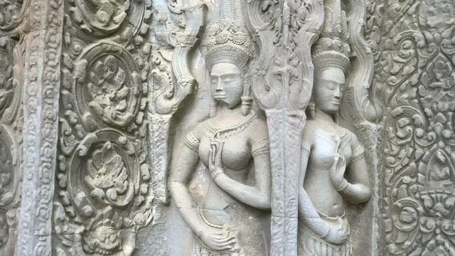 tilt down shot of two devata at ta prohm temple near angkor wat, cambodia