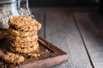 Homemade oatmeal cookies on wooden board on old table background. Healthy Food Snack Concept. COpy...