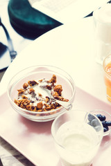 Granola with yogurt on white marble table at coffee shop. Breakfast or lunch time. Healthy lifestyle, slow living, minimalistic concept