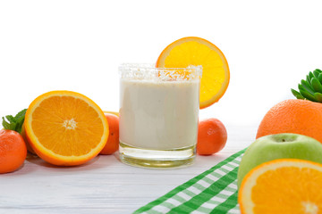 Smoothies with bananas and oranges, a sprig of mint on a white background. Space for text or design.