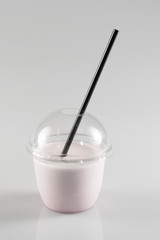 Glass of milkshake in plastic transparent cup isolated on white background