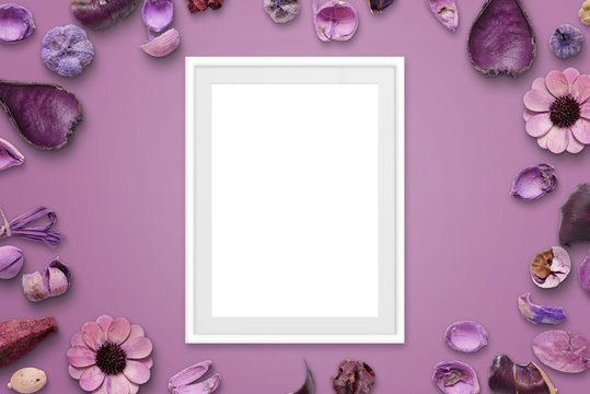 White picture frame on pink background surrounded with flower decorations.