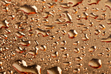 Colored water droplets on a gold background. Abstract liquid sprays