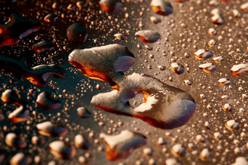 Colored water droplets on a gold background. Abstract liquid sprays