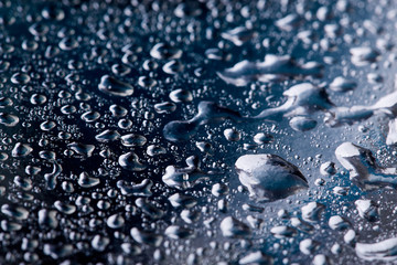 Colored water droplets on a gold background. Abstract liquid sprays