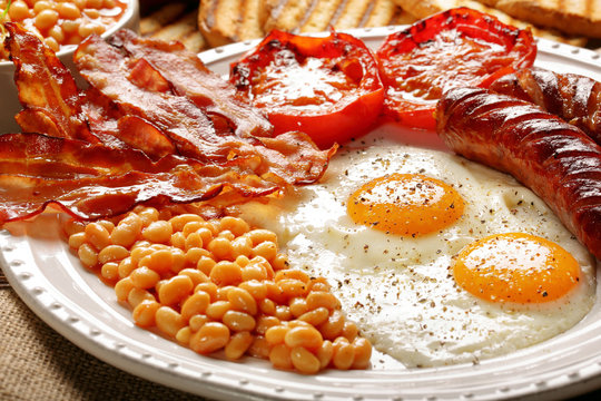 English Breakfast with sausages, grilled tomatoes, egg, bacon, beans and bread