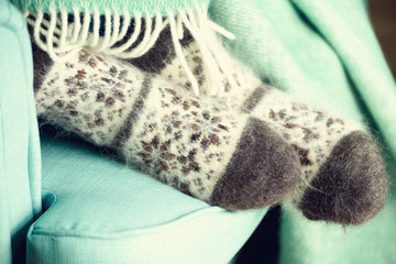 Feet in woolen socks. Cozy autumn evening. Winter and Christmas holidays concept. Copy space
