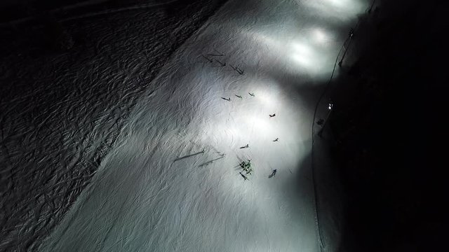 Drone aerial view of skiers on the slope, night skiing at Monte Pora ski resort