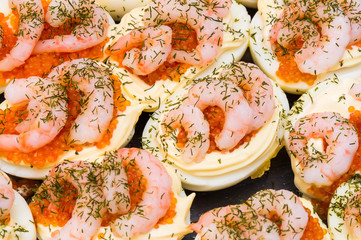 Traditional christmas easter dish egg halves with shrimp and mayonaise and caviar on top.