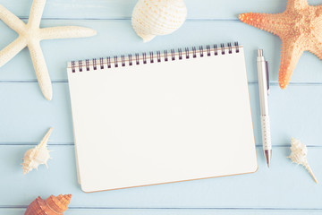 A blank note with starfish and sea shells on a blue wooden floor,summer concept