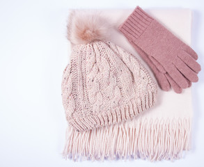 Warm winter knitted clothes - hat, scarf, gloves on a white background.