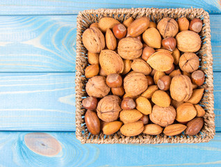 Different types of nuts in a shell on a wooden background.