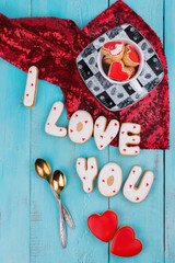 Homemade cookies in the form of a heart or I love you words on Valentine's Day on a blue board top view