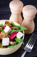 Spinach salad with nuts and apples served on table