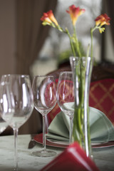 Freesias in a vase and empty glasses on a restaurant table. Elegant style.