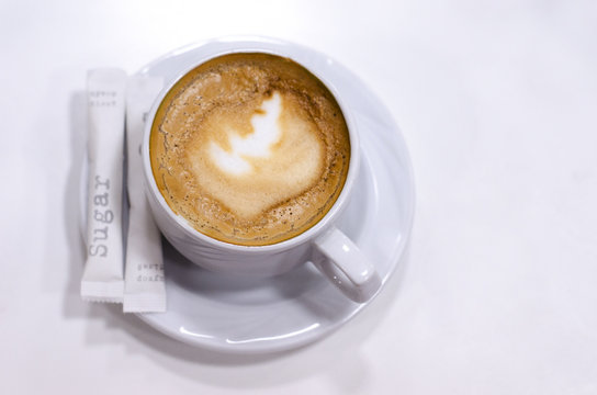 Cup of coffee on a saucer and two sachets of sugar, great design for any purposes. Espresso coffee. Coffee background. Coffee cup isolated. Coffee closeup. White cup