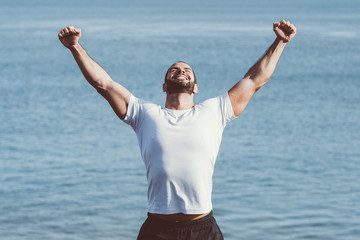 Happy Strong Man Celebrating Sport Success at Sea