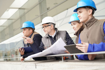 Construction manager giving instructions to training students
