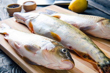 Uncooked fish on cutting board in meal preparation concept