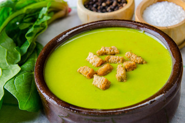 Spinach soup served on wooden board 