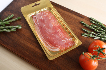 bacon in packing on a wooden background