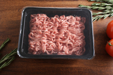 minced meat in packing on a wooden background