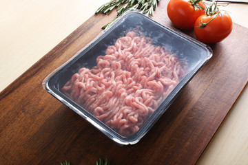 minced meat in packing on a wooden background