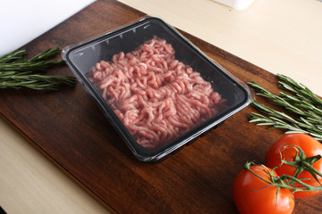 minced meat in packing on a wooden background
