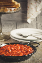 Beans in tomato sauce in a frying pan on a dark background