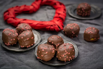 Valentine's Day concept, chocolate profiteroles with pink hearts, stuffed cakes,  special romantic event.