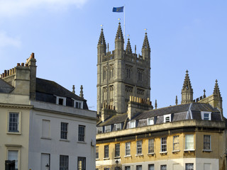 Fototapeta na wymiar The tower of Bath Abbey rising above nearby buildings, City of Bath, UK